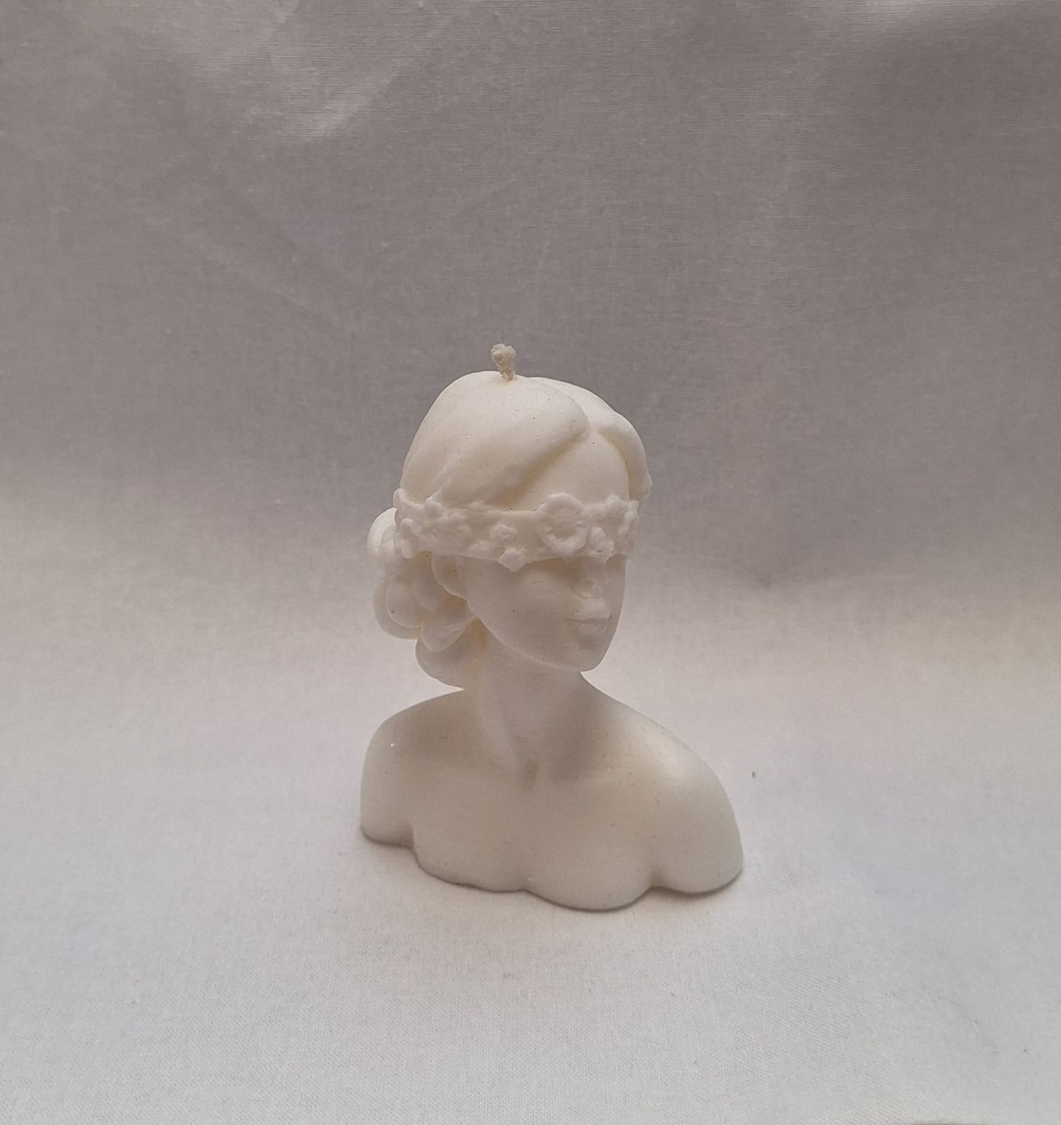 Handmade sculpted bust candle of a woman with flower blindfold, unique decorative soy wax candle for gifts or home decor.