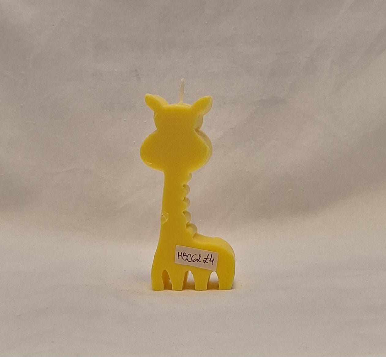 Yellow handmade giraffe-shaped candle with polka dots, perfect for jungle-themed baby showers, kids’ birthdays, or safari party décor.