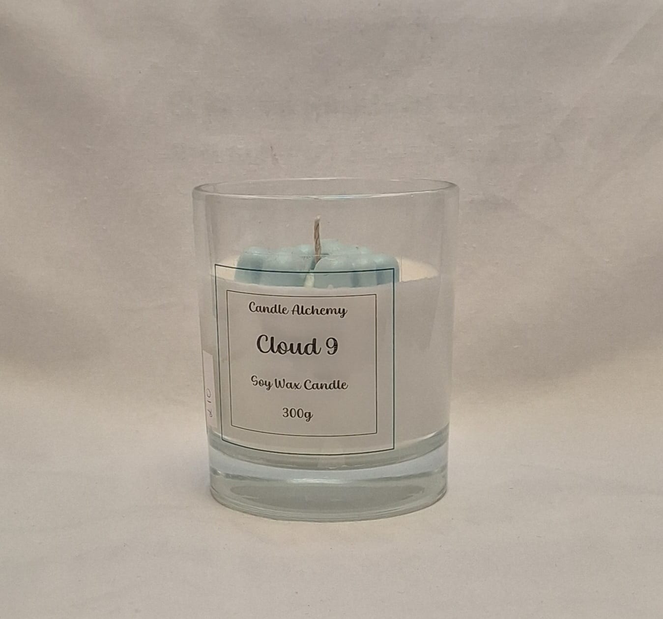 Unboxed Cloud 9 soy wax candle showing blue clouds top inside a clear glass container, 300g.