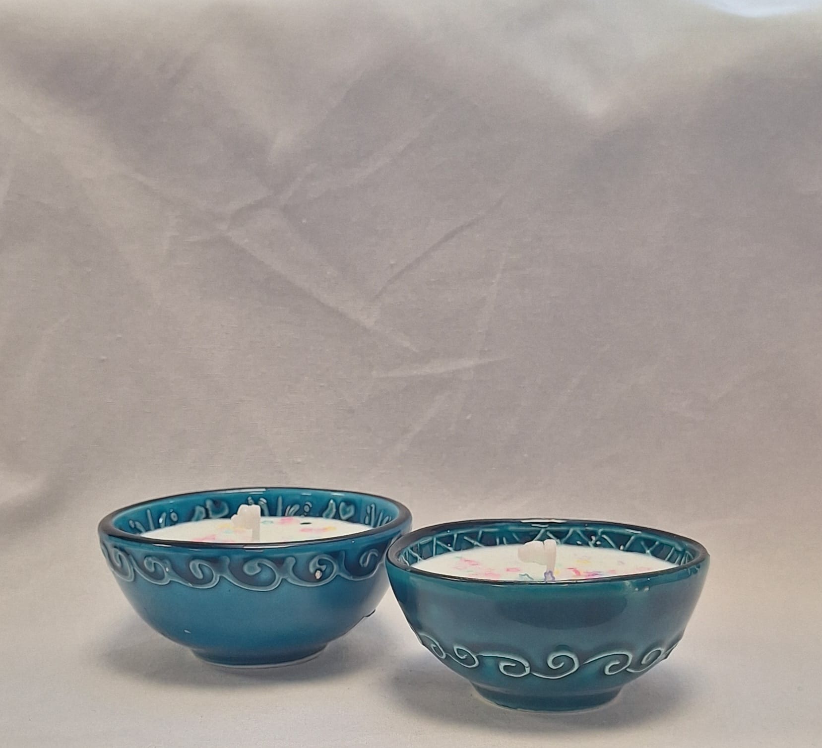 Hand-poured soy candle in blue glazed ceramic bowl with pastel star glitter topping for decorative home use or gifting.