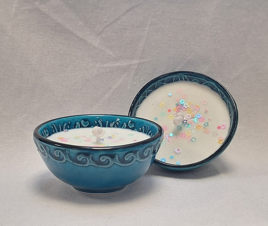 Hand-poured soy candle in blue glazed ceramic bowl with pastel star glitter topping for decorative home use or gifting.